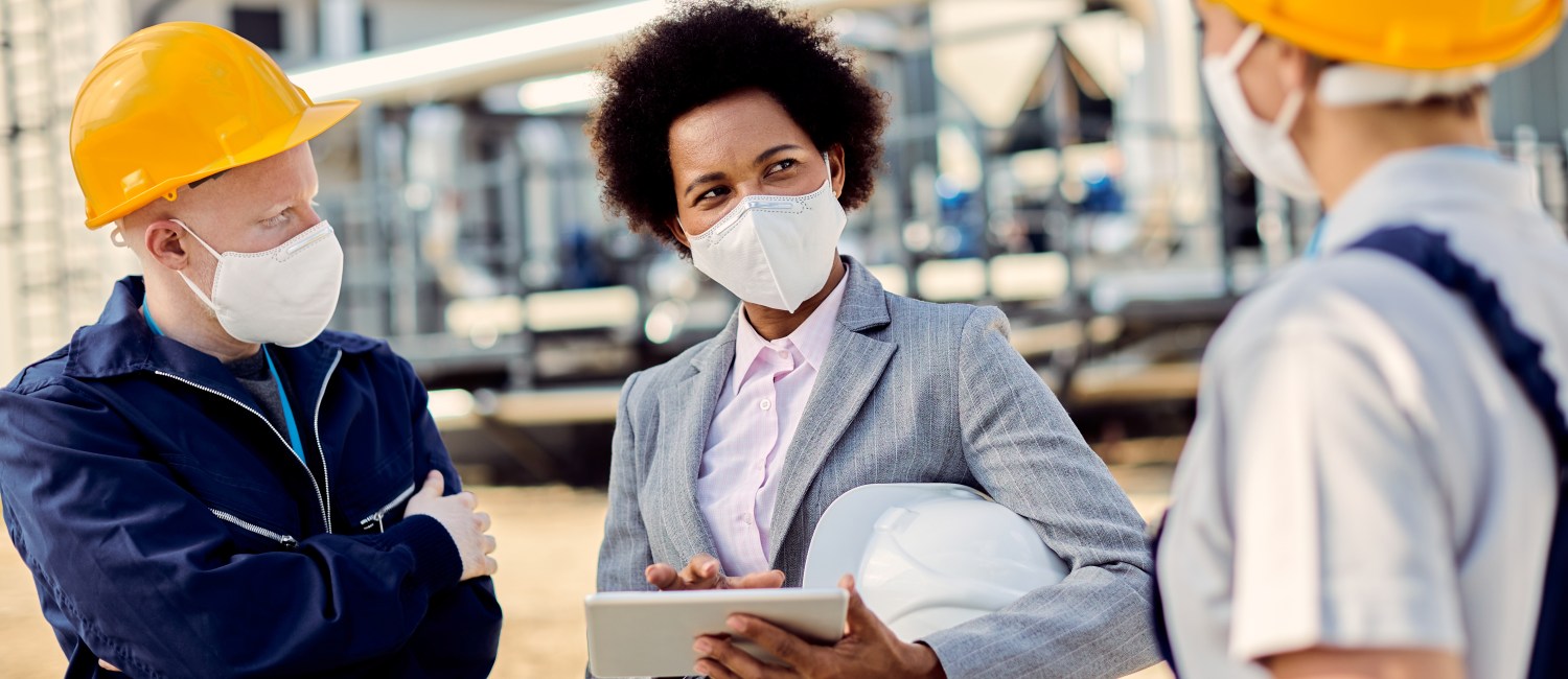 African American building contractor talking to civil engineers