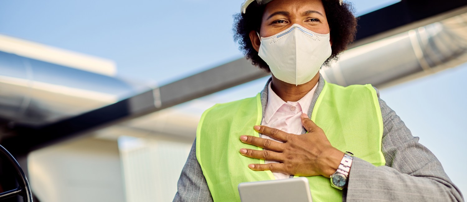 Black female building contractor with face mask feeling chest pa